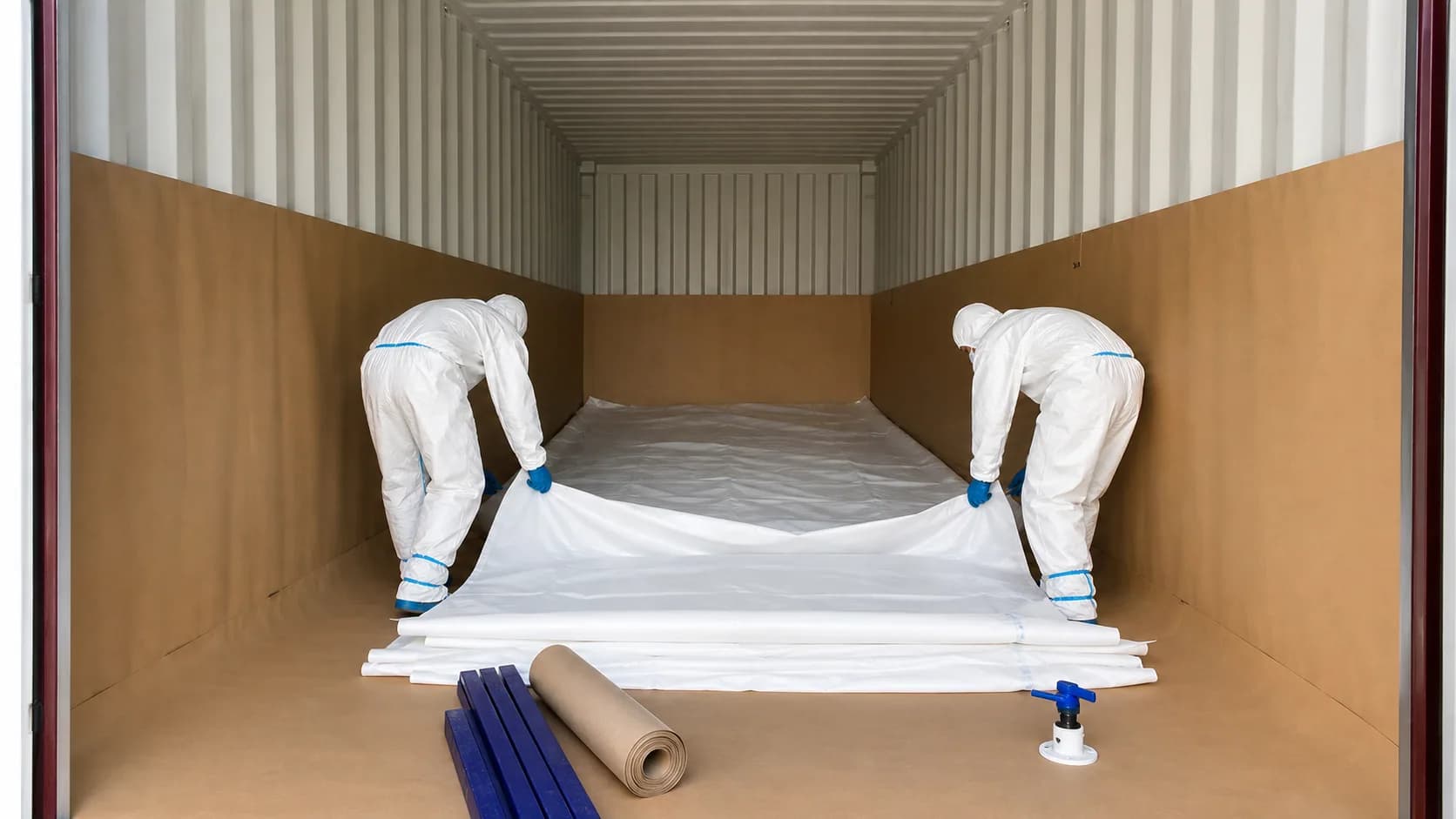 Technicians positioning a Flexitank liner in a protected 20ft container
